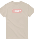 Stilren illustration med texten Honey på sandfärgad t-shirt