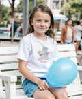 Pop-it enhörning, regnbåge, siffra 5 och text "Happy Birthday Alma" på vit barntröja.