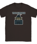 Tecknat troll med argt leende bakom datorskärm, text "TROLLFABRIKEN", på mörkbrun T-shirt.
