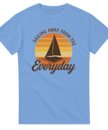 Blå t-shirt med retroinspirerat segelbåtsmotiv i solnedgångsfärger och texten "Sailing Away From The Everyday" – perfekt för havsälskare och seglare