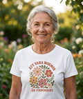 Leende kvinna i trädgård bärande en t-shirt med vintageinspirerat blomtryck