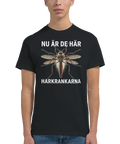 Man bär en svart t-shirt med grafiskt tryck av en harkrank