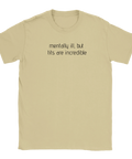 Svart text "mentally ill, but tits are incredible" på en sandfärgad t-shirt, humoristisk och provokativ design.