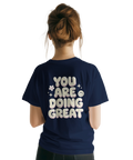 Stort ryggtryck med texten You Are Doing Great på marinblå t-shirt