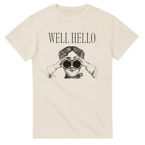 Vintage kvinna med kikare och text "WELL HELLO" på en krämfärgad t-shirt.
