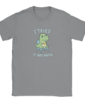 T-shirt med tecknad grön dinosaurie som sitter på stol med "Meh"-medalj och texten "I tried, it was awful".