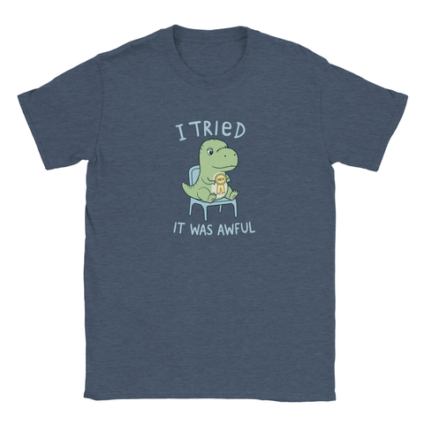 Grön dinosaurie med "MEH"-medalj och text "I TRIED IT WAS AWFUL" på marinblå t-shirt.