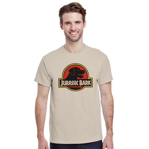 Jurassic Bark-logga med svart hundprofil i röd cirkel, text "Jurassic Bark" på beige t-shirt.
