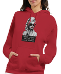 Marilyn Monroe-inspirerad kvinna med solglasögon, rött läppstift, text "Ingen jävel kallar mig lilla gumman" på röd hoodie.
