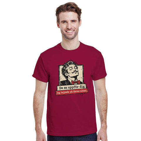 Modell i vinröd t-shirt med mansporträtt med fluga och texten ”De sa uppför dig. Jag bajsade på deras altan.”