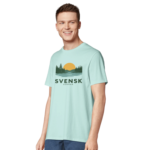Svensk Sommar-tryck med skogssilhuett, sjö och solnedgång på ljusblå ekologisk t-shirt.