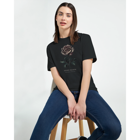 Sittande modell bär en t-shirt med stämningsfull grafisk illustration