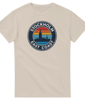 Stockholm East Coast retro-tryck med stadssiluett och solnedgång på beige t-shirt.