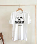 Stilren t-shirt med minimalistisk svensk flaggsymbol hängande på en trägalge