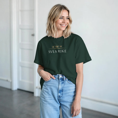 Tre guldkronor och "SVEA RIKE" text på mörkgrön t-shirt, buren av kvinna med ljusa jeans.