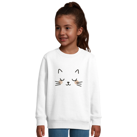 Barn i vit sweatshirt med grafiskt kattansikte och rosa kinder