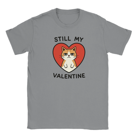 Grinig orangevit katt i rött hjärta, text "STILL MY VALENTINE" på grå t-shirt.