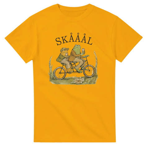 Charmigt tryck med grodor på cykel och texten Skååål – grafisk t-shirt