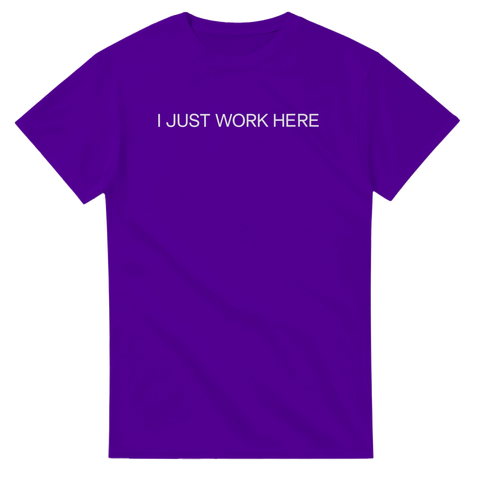 I Just Work Here" texttryck i vit, enkel stil på lila t-shirt.