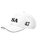Vit keps med marinblå kant, texten "USA" och siffran "47" i svart blockstil.