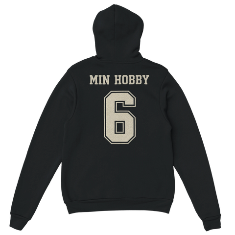 Min Hobby 6" i beige college-stil på svart hoodie.