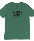 Shirty Works Est. 2025 logotyp på djupgrön triblend t-shirt.