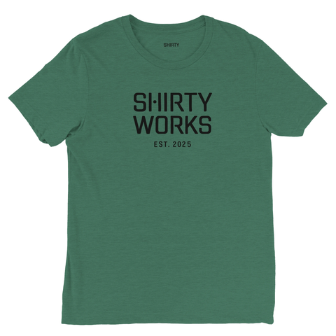 Shirty Works Est. 2025 logotyp på djupgrön triblend t-shirt.