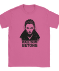 Kvinna med intensiv blick, svart krage, text "KALL SOM BETONG" på rosa t-shirt.