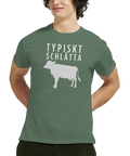 Vitt ko-motiv och text "TYPISKT SCHLÄTTA" på olivgrön t-shirt.