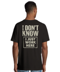 Man bär svart oversized t-shirt med stort ryggtryck och ironisk text