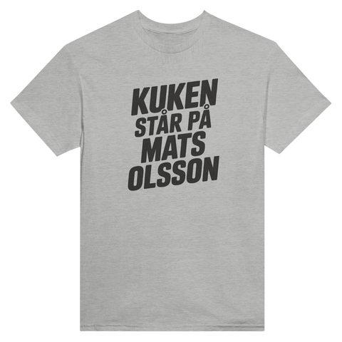 Satiriskt tryck "Kuken står på Mats Olsson" i svart på grå t-shirt, fet stil.