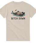Söt illustration av en flytande utter med texten Bitch Down på beige t-shirt