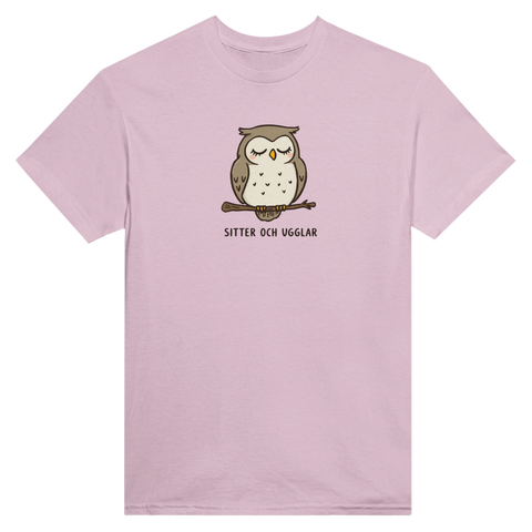 Tecknad sovande uggla på gren med texten "SITTER OCH UGGLAR" på ljusrosa t-shirt.