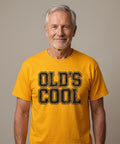Old's Cool" text i sliten retrostil på senapsgul t-shirt.