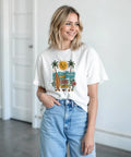 Kvinna bär en vit t-shirt med somrigt No Bad Days motiv