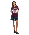 Vit text "QUEEN 69" med dubbel kontur på vinröd t-shirt, sportig college-stil.
