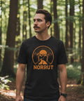 Man med mustasch bär en t-shirt med naturmotiv i en lummig skogsmiljö