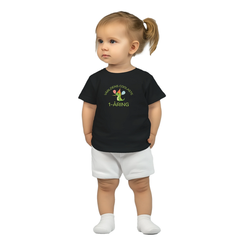 Tecknad grön dinosaurie med kalashatt och ballonger, text "Världens coolaste 1-åring" på svart baby-t-shirt.