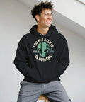 Leende man bär en svart hoodie med ett humoristiskt alien-motiv i retrostil