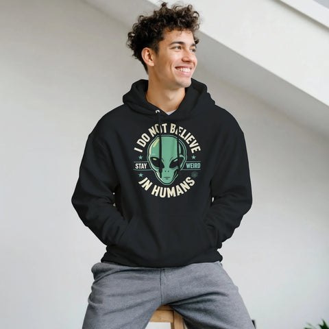Leende man bär en svart hoodie med ett humoristiskt alien-motiv i retrostil