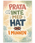 Inredningsbild som visar en poster med texten Prata inte med hat i munnen i en modern träram på en ljus vägg vid en arbetsplats.