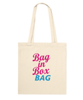 Texten "Bag in Box BAG" i rosa och blått på en naturvit tygkasse.