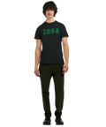 Man bär svart t-shirt med grönt 1894-tryck framifrån