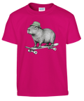 Rosa barn-t-shirt med en kapybara i grön mössa på skateboard.