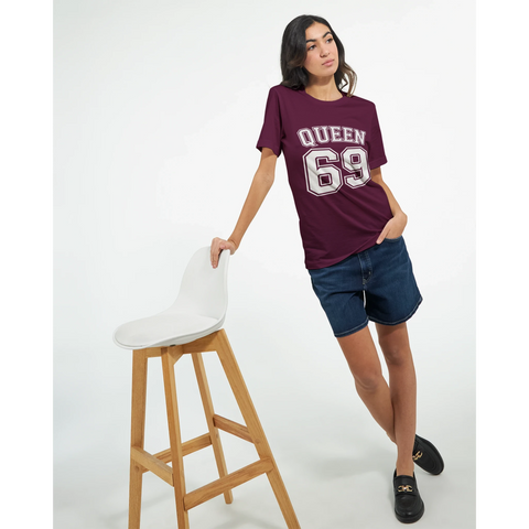 Vit text "QUEEN 69" med dubbel kontur på vinröd t-shirt, sportig college-stil.