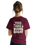 You Are Doing Great" text med smiley och stjärnor på vinröd t-shirt.