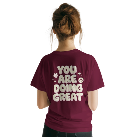 You Are Doing Great" text med smiley och stjärnor på vinröd t-shirt.