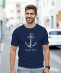 Man bär en marinblå t-shirt med grafiskt ankarmotiv och texten Kapten