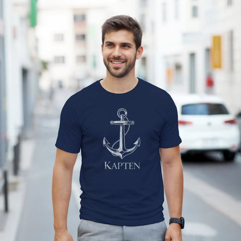 Man bär en marinblå t-shirt med grafiskt ankarmotiv och texten Kapten