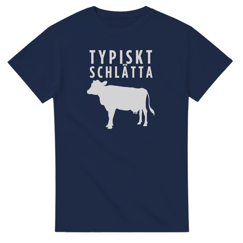Typiskt Schlätta" text och ko-silhuett i vitt på marinblå t-shirt.